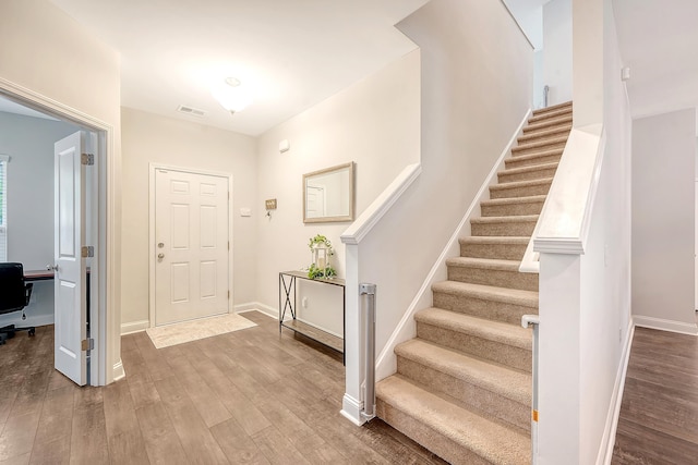 entryway featuring stairway, baseboards, and wood finished floors