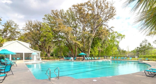 pool with a patio and fence