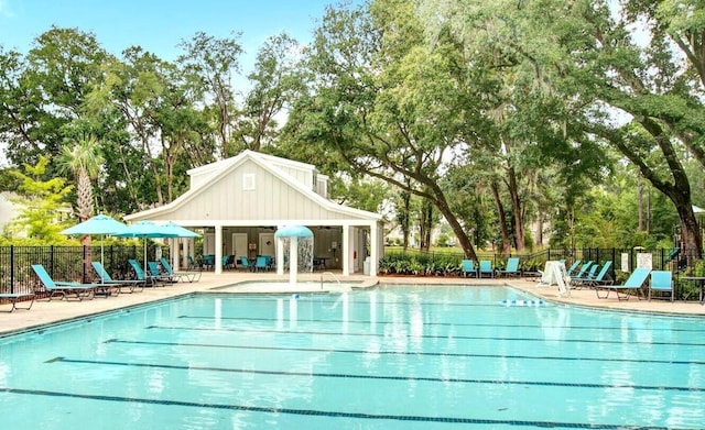 pool with a patio area and fence