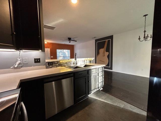 kitchen featuring sink, dark wood-type flooring, decorative light fixtures, ceiling fan with notable chandelier, and appliances with stainless steel finishes