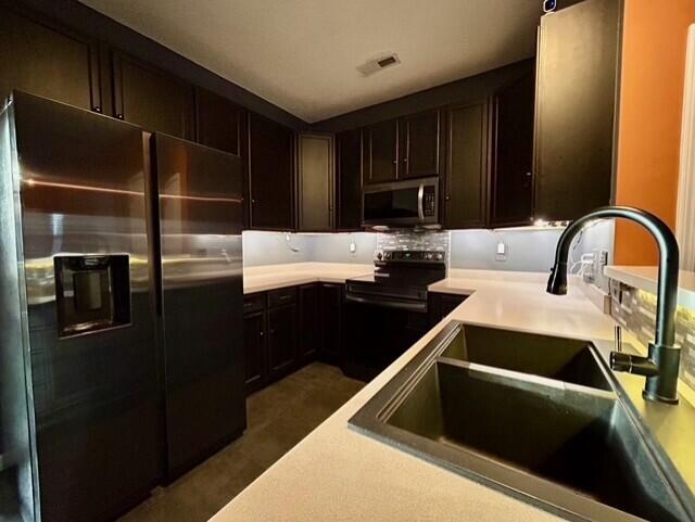 kitchen featuring dark brown cabinetry, stainless steel appliances, and sink