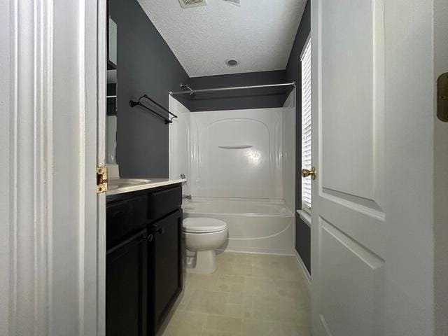 full bathroom featuring vanity, a textured ceiling, toilet, and plenty of natural light