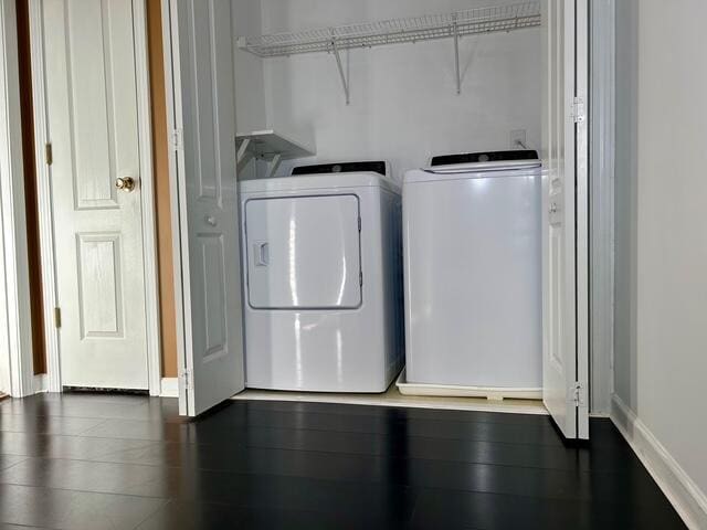 laundry room with dark hardwood / wood-style flooring and washing machine and dryer