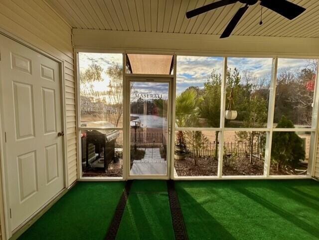 unfurnished sunroom featuring ceiling fan and wood ceiling