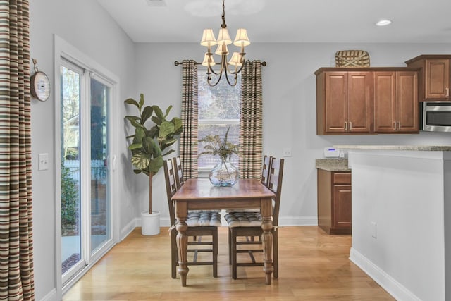 dining area featuring a notable chandelier and light wood-type flooring