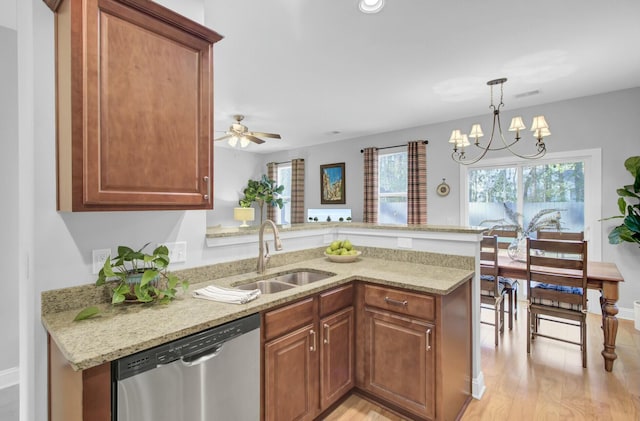 kitchen featuring stainless steel dishwasher, kitchen peninsula, sink, light hardwood / wood-style flooring, and ceiling fan with notable chandelier