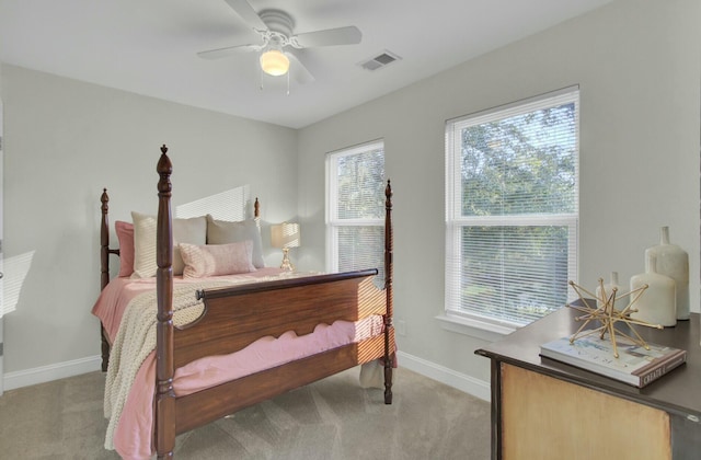 carpeted bedroom featuring ceiling fan and multiple windows