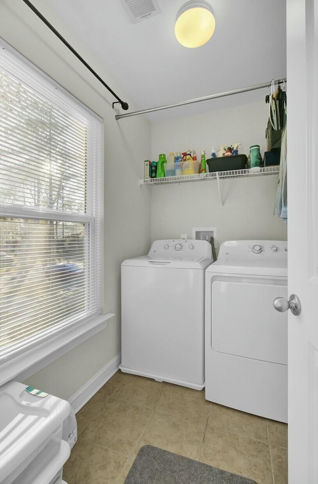 laundry room featuring washing machine and dryer and light tile patterned floors