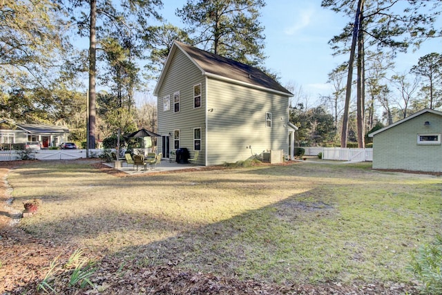 view of side of property featuring a patio area and a lawn