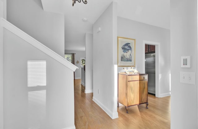 hallway featuring light hardwood / wood-style flooring and a notable chandelier