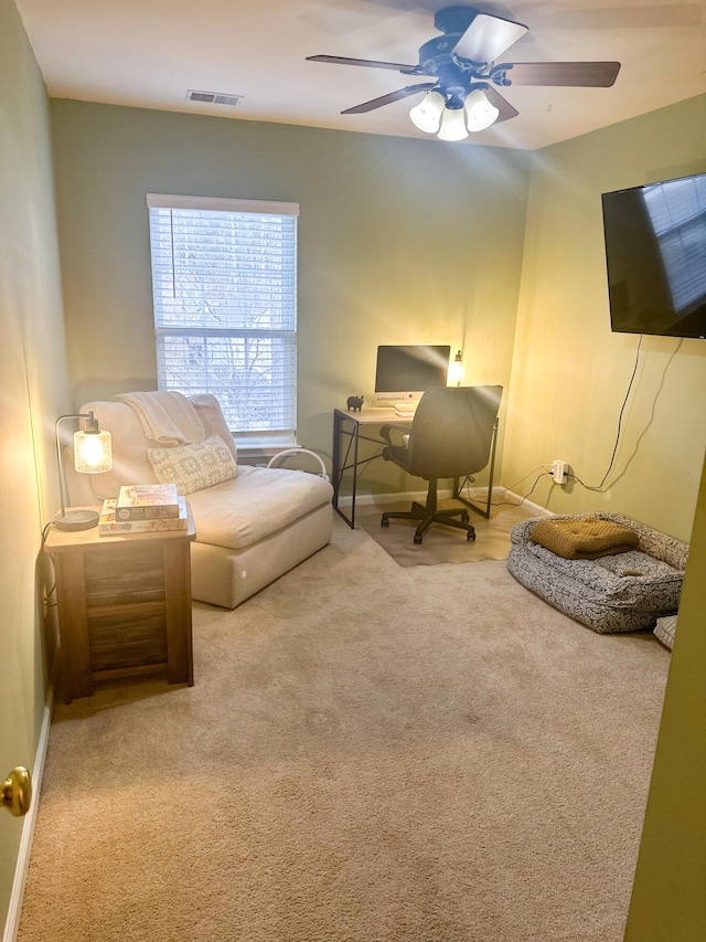 living area featuring carpet floors and ceiling fan