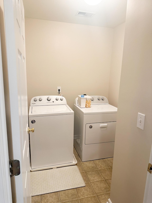 laundry area with washing machine and dryer and light tile patterned flooring