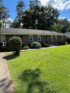 single story home featuring a front lawn