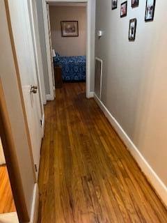 corridor with hardwood / wood-style flooring