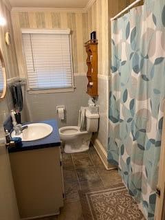 bathroom featuring tile floors, ornamental molding, vanity, and toilet