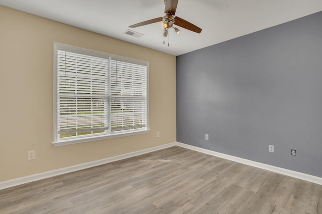 empty room with ceiling fan and light hardwood / wood-style floors