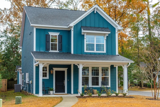 view of front facade with a porch, a front lawn, and central air condition unit