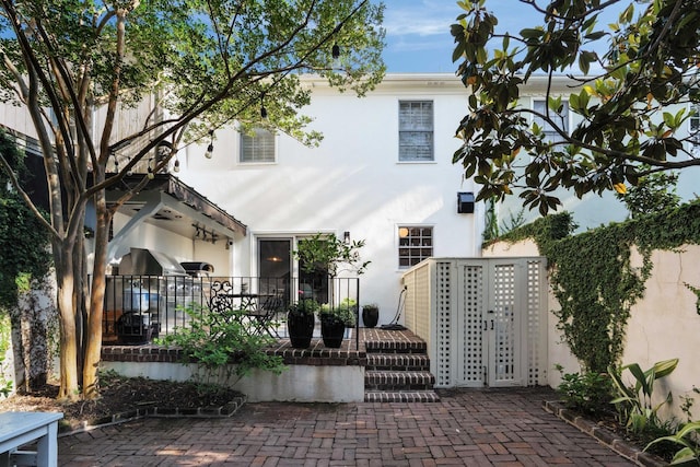 1661/2 Queen St, Charleston, SC 29401 - view of front of home featuring stucco siding, a patio, and fence