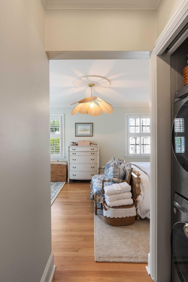 1661/2 Queen St, Charleston, SC 29401 - bedroom featuring stacked washing machine and dryer, light wood finished floors, crown molding, and a ceiling fan