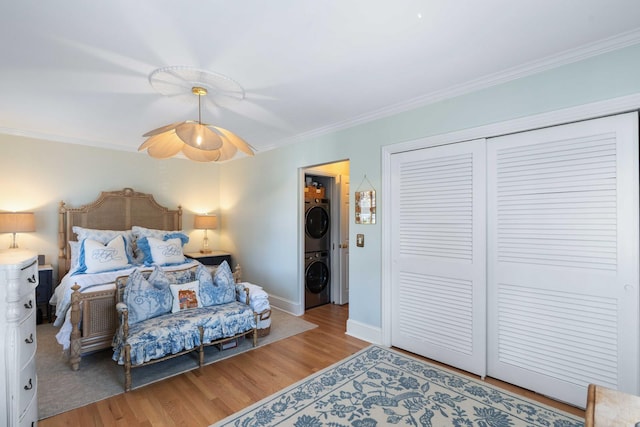 1661/2 Queen St, Charleston, SC 29401 - bedroom with estacked washer and dryer, wood finished floors, crown molding, a closet, and baseboards