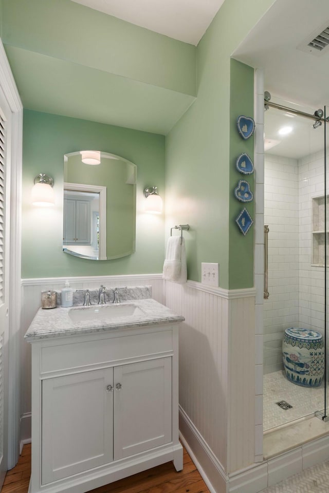 1661/2 Queen St, Charleston, SC 29401 - bathroom featuring wainscoting, a shower stall, vanity, and wood finished floors