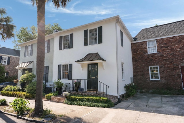 1661/2 Queen St, Charleston, SC 29401 - view of front of home featuring a standing seam roof, stucco siding, metal roof, and brick siding