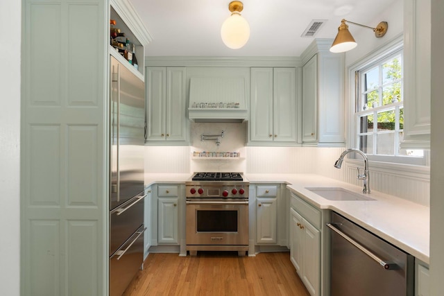 1661/2 Queen St, Charleston, SC 29401 - kitchen with high quality appliances, a sink, light wood-style flooring, light countertops, and premium range hood