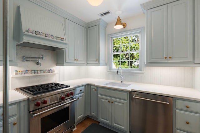 1661/2 Queen St, Charleston, SC 29401 - kitchen featuring stainless steel appliances, a sink, custom exhaust hood, light countertops, and gray cabinets