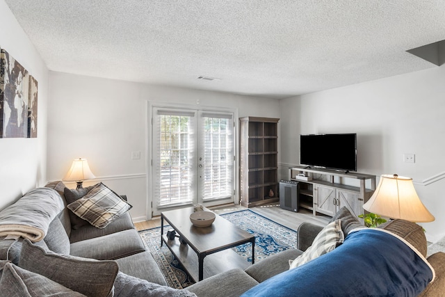 living room featuring a textured ceiling and light hardwood / wood-style floors