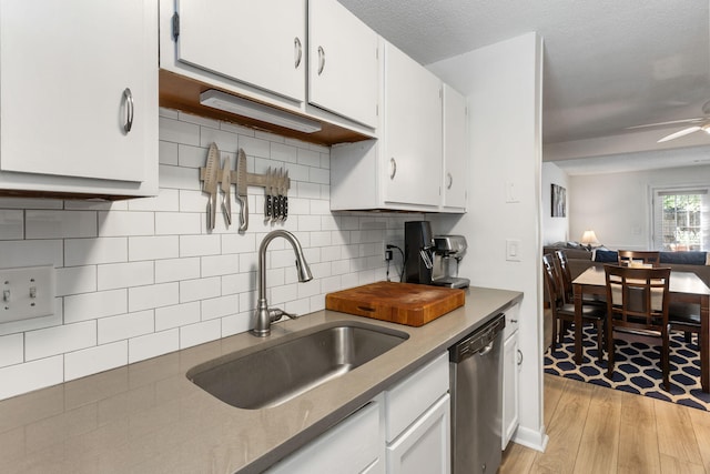 kitchen featuring ceiling fan, sink, white cabinetry, dishwasher, and light wood-type flooring