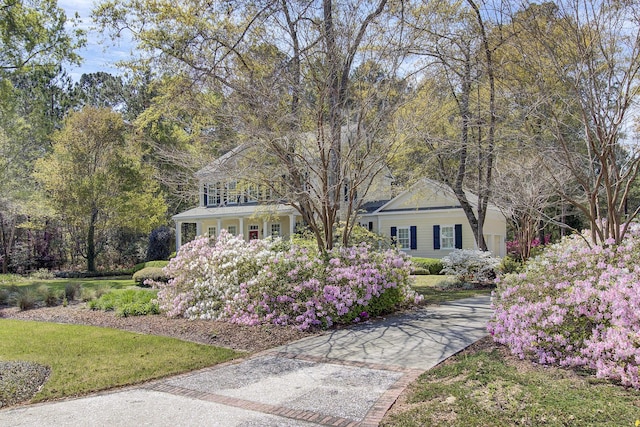 view of property's community with a yard and concrete driveway