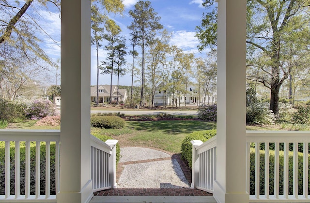 view of green lawn with covered porch