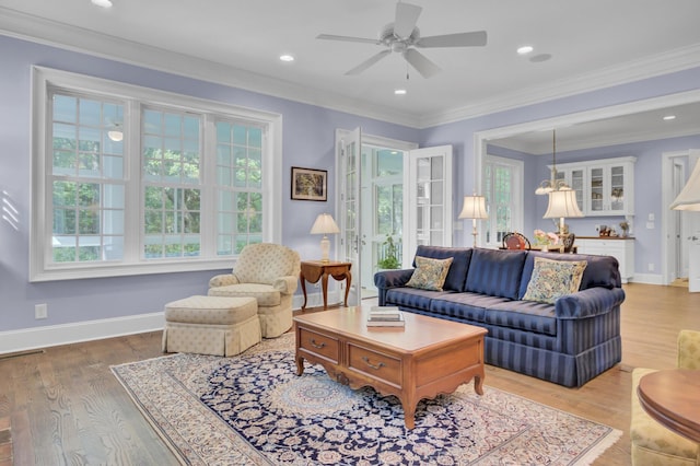 living area featuring a ceiling fan, light wood-style flooring, baseboards, crown molding, and recessed lighting