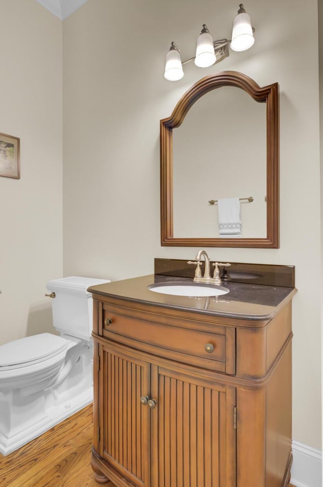 bathroom featuring toilet, vanity, and wood finished floors