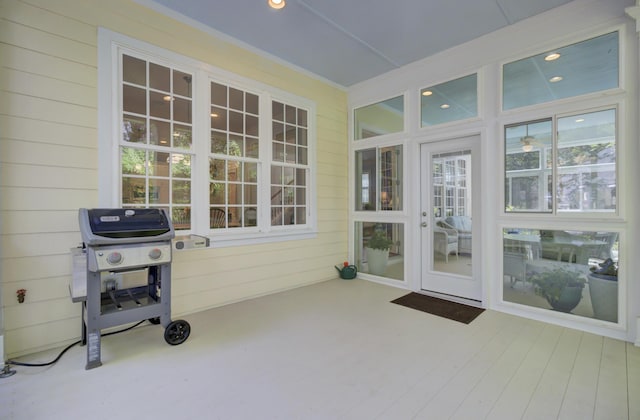 sunroom featuring wood walls and plenty of natural light