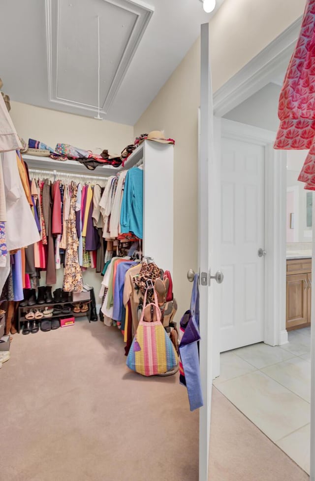 spacious closet with attic access and light carpet