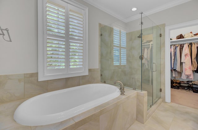 bathroom featuring a shower stall, a garden tub, crown molding, and a walk in closet