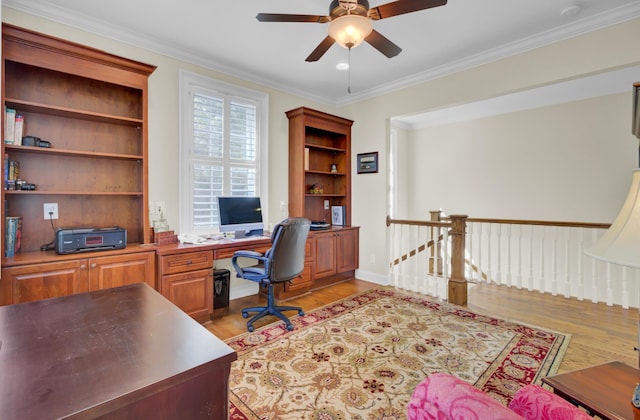office space with light wood-style flooring, a ceiling fan, crown molding, and baseboards