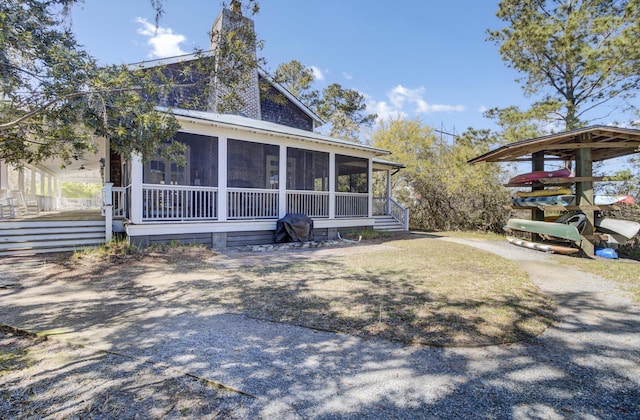 view of front of home with a sunroom and a chimney