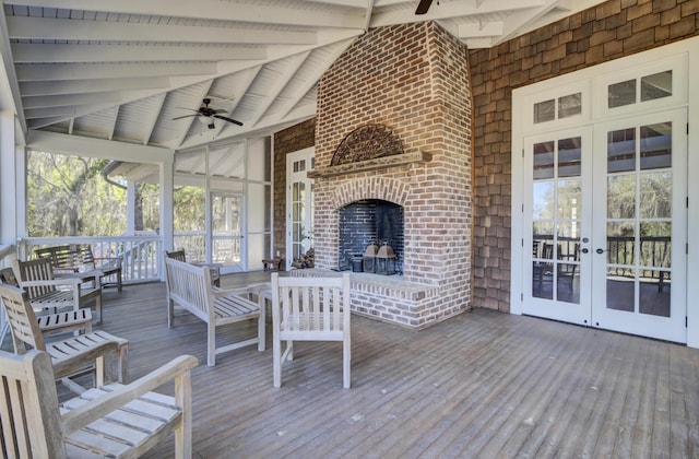 deck featuring french doors, an outdoor brick fireplace, and ceiling fan
