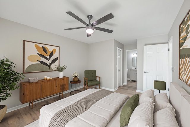 bedroom featuring ensuite bathroom, ceiling fan, and light wood-type flooring