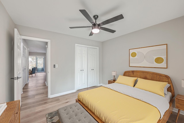 bedroom with ceiling fan, light hardwood / wood-style floors, and a closet