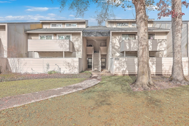 view of front of home with a front lawn and a balcony