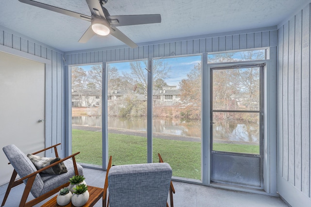 sunroom with a water view and ceiling fan