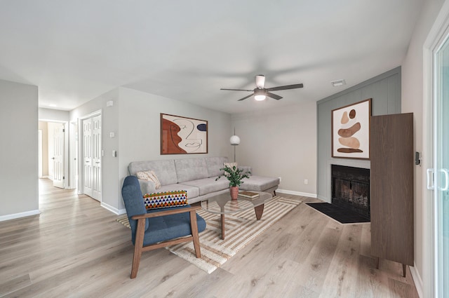 living room featuring light wood-type flooring and ceiling fan