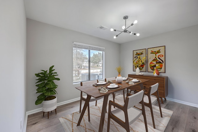 dining area featuring a notable chandelier and light hardwood / wood-style flooring