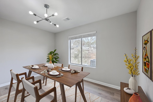 dining area featuring an inviting chandelier and light hardwood / wood-style floors