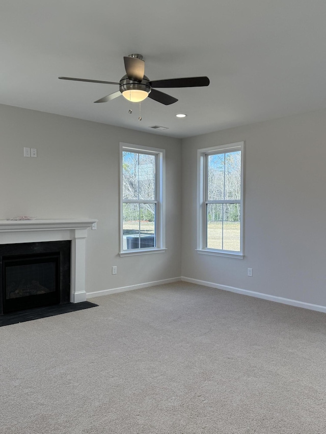 unfurnished living room with a wealth of natural light, baseboards, and carpet floors