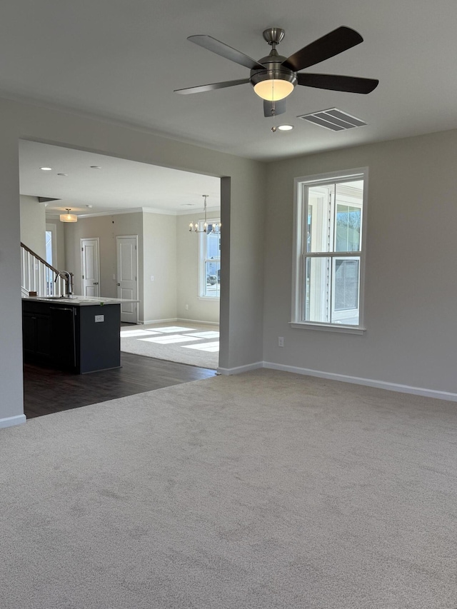 unfurnished living room with dark colored carpet, visible vents, and baseboards