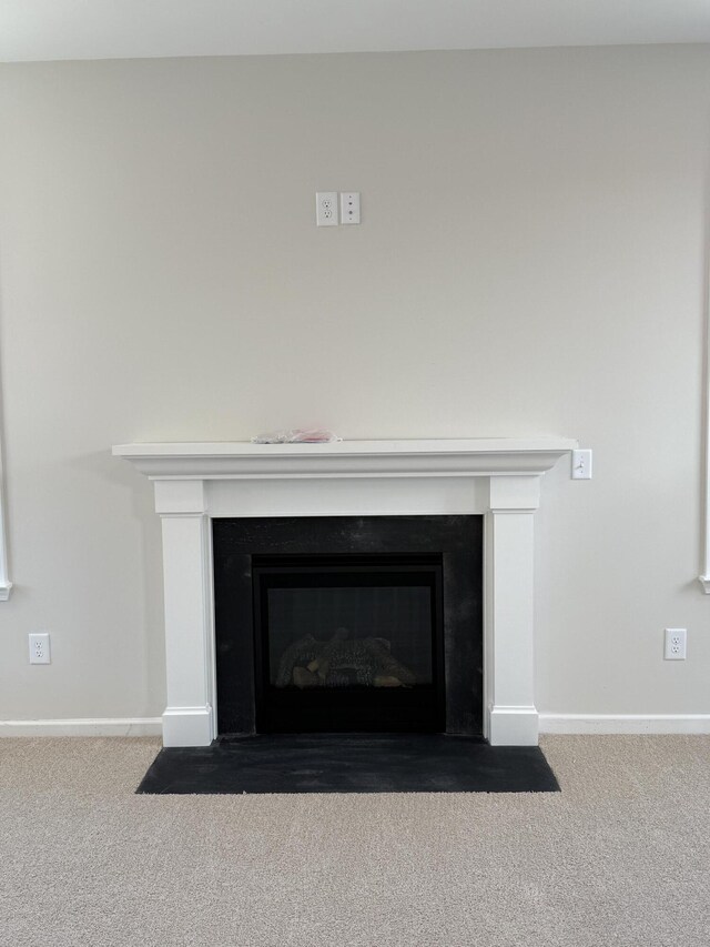 room details featuring a fireplace with flush hearth, carpet, and baseboards